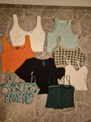 8 snygga toppar - Säljer ett paket med 8 snygga toppar i olika färger och modeller✨️😍 Köp alla för 290 kr eller 70 kr/st (frakten blir billigare vid enskildt köp). Pris går att diskuteras. Inkluderar ribbade linnen i vitt, orange och mintgrönt, en svart v-ringad topp, en grön smockad topp, en vit topp med tunna axelband, en beige-rutig topp och en mönstrad topp. Den enfärgade mintgröna och den oranga är i bra skick, resten är i mycket bra skick.  Det är bara att skriva om man har frågor!😊💖