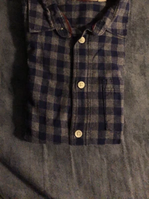 Blåruttig skjorta med knappar  - Blåruttig skjorta med knappar som är för barn i 10-11 åldrande alltså 140-145 cm