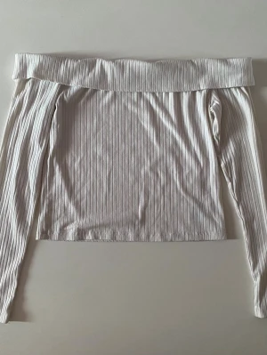 Vit ribbad offshoulder topp  - Säljer en vit ribbad offshoulder topp från H&M Divided i storlek L ( känns som M ).