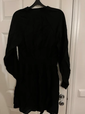 Svart långärmad klänning från MSGM - Snygg svart klänning från MSGM med lång ärm och diskret diagonalt mönster i tyget. Klänningen har en rak passform och är tillverkad i ett lätt material som ger ett elegant fall. Perfekt för dig som gillar stilrena och moderna plagg.