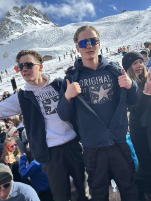 Mörkblå hoodie med stjärntryck - Säljer en mörkblå hoodie från Original Fit med stort vintageinspirerat stjärntryck och text 'EST. 2024' på bröstet. Hoodien har huva med dragsko och en klassisk magficka. Perfekt för dig som gillar en avslappnad och cool stil.