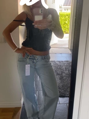 Ljusblåa wide leg jeans från Gina Tricot - Säljer ett par ljusblåa wide leg jeans från Gina Tricot. Jeansen har hög midja, klassisk femficksdesign och raka, vida ben. Tillverkade i denim med en avslappnad passform som ger en trendig och bekväm look.
