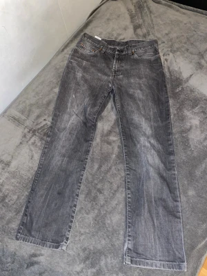 Grå raka jeans från Edwin - Säljer ett par grå jeans från Edwin med rak passform och klassiska fem fickor. Jeansen har en snygg tvättad look och är tillverkade i denim. Perfekta för dig som gillar en avslappnad stil.