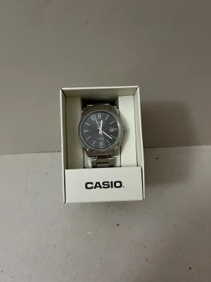 Casio - Bilderna visar en Casio-klocka i originalförpackning och i en mörkgrå och nästan elegant färg. Använd men i ett mycket bra skick. Bara att höra av sig om det finns frågor.