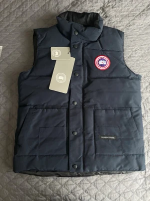 Mörkblå dunväst från Canada Goose - 1-1, Helt ny.                                                                           Priset kan diskuteras, skriv vid funderingar eller intresse😊