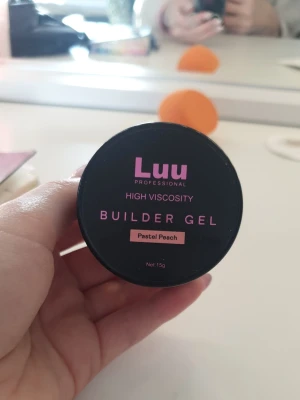 Luu Builder Gel Pastel Peach - Byggel från Luu Professional i färgen Pastel Peach. Gelen har hög viskositet och kommer i en rund burk på 15g. Perfekt för att bygga och forma naglar med en mjuk persikoton. Enkel att applicera och ger ett snyggt resultat.