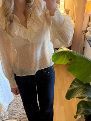 Vit volangblus från Zara - Söt vit blus från Zara med volangdetaljer runt v-ringningen och diskret prickigt mönster. 💕