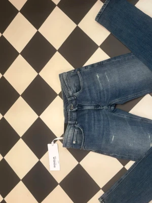 Blå slim fit jeans från Dondup - Snygga blå slim fit jeans från Dondup med slitna detaljer och klassisk femficksmodell. Jeansen har normal midja, dragkedjegylf och är tillverkade i stretchigt denimtyg för skön passform. Perfekta för en trendig och avslappnad look. Helt nya pris lapp. Aldrig andvända. Eftersom de var för små. Kom med frågor 