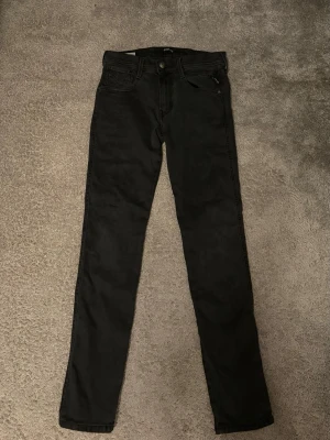 Svarta replay anbass  - Säljer nu dessa svarta replay anbass jeans i slim passform, storlek 28W 30L som är i riktigt bra skick, skriv till mig om ni har några frågor om jeansen!🌟🙌