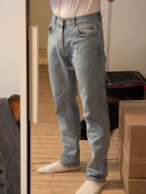 Ljusblå raka jeans - Säljer ett par ljusblå jeans med rak passform och klassisk femficksdesign. Jeansen har normal midja och är tillverkade i denim. Perfekta för en avslappnad och stilren look.