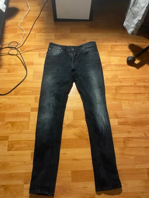 Svarta slim fit jeans - Snygga svarta slim fit jeans med lätt tvättad look och klassisk femficksdesign. Jeansen har dragkedjegylf och raka ben. Perfekta för en avslappnad och trendig stil. Materialet är troligtvis bomull med stretch för extra komfort.