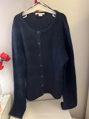 Mörkblå fluffig kofta från Gina Tricot - Mörkblå stickad kofta från Gina tricot u storleken 146-152. Bra skick. 