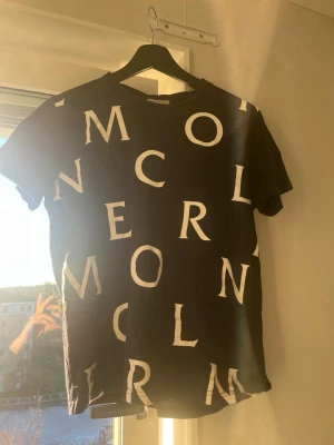  Mörk Blå Moncler T-Shirt - Säljer min blå moncler t-shirt eftersom jag har växt ut den. Fint skick förutom ett pyttelitet hål (bild sista sidan) men syns inte. Priset är inte hugget i sten.