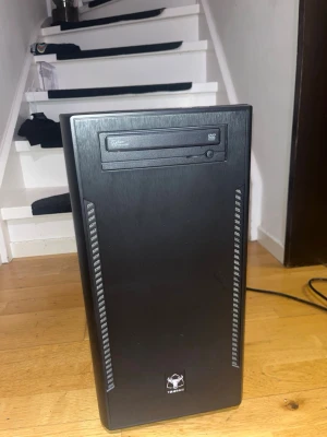 Svart stationär dator med DVD-läsare - Säljer en svart stationär dator i stilren design med frontmonterad DVD-läsare och flera USB-portar på ovansidan. Chassit är tillverkat i metall och plast med diskreta ventilationsgaller på framsidan. Perfekt för gaming, studier eller vardagsbruk. Den har vart med i något år, Men jag har spelat Fortnite,Roblox o cs! Säljer den billigt för vill bli av med den