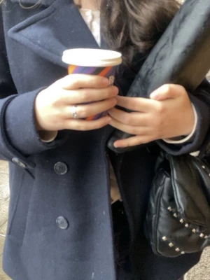 Mörkblå ellos dubbelknäppt kappa - Stilren mörkblå kappa med dubbelknäppning och bred krage. Klassisk design med stora knappar och raka ärmar. Perfekt för dig som vill ha en tidlös och snygg look till hösten eller vintern.