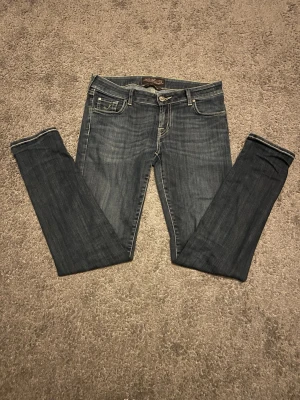 Mörkblå jeans från Jacob Cohen - Snygga mörkblå jeans från Jacob Cohen med klassisk femficksmodell och smal passform. Jeansen är handgjorda i Veneto, Italien och har guldfärgade sömmar samt detaljerad innerficka. Perfekta för dig som gillar stilrena och exklusiva jeans, nypris över 5000kr 