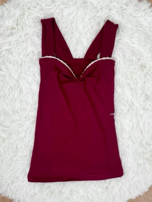 Vinröd linnetopp med breda axelband - Snygg vinröd linnetopp med breda axelband och en lätt draperad urringning. Storlek: XXS (32), byst under 80cm, midjan under 64cm.