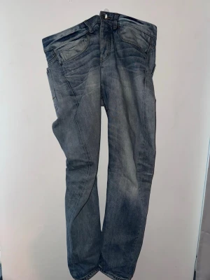 Blå raka jeans med ovanlig fade - Säljer ett par blå jeans med raka ben och snygga slitningar. Jeansen har en riktigt ovanlig och snygg tvätt med slitningar. Skriv Järna vid minsta fråga.  OBS jag vet ej märket. 