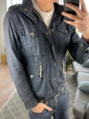 Mörkblå Fieldjacket - Väldigt snygg och perfekt till alla tillfällen! Mått: A:54 B:50 C:47 D:61 (cm) Skriv vid fundering 😊✌️