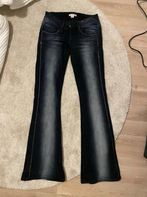 Lågmidjade jeans - Säljer ett par mörkblå bootcut jeans från Gina 14 i storlek S. Några av diamanterna har lossnat men inget man tänker på💕 Endast använda en gång🤍
