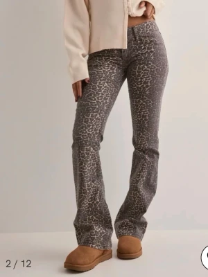 Grå leopardmönstrade bootcut jeans - Snygga grå jeans med leopardmönster och bootcut-modell från Nelly. Jeansen har klassisk femficksdesign och normal midja. Perfekta för dig som vill sticka ut med ett trendigt djurmönster. De är som nya använda fåtal gånger så inga bieffekter, slutsålda på hemsidan😊skriv om du har några funderingar! 