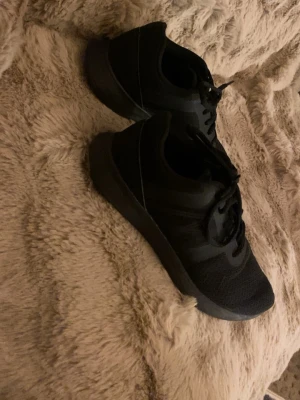 Helvita svarta sneakers med mesh - Snygga helsvarta sneakers med ovandel i mesh och syntetmaterial. Skorna har klassisk låg profil, snörning och en stilren design som passar till det mesta. Perfekta för dig som gillar en clean och sportig look. Använt några gånger men ser ut som helt nya, fräscha, inga skador eller smuts på. 