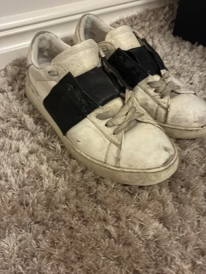 Valentino open svart vita -   Äkta Valentino Open sneakers. Använda med synligt slitage och sprickor i sulan (se bilder). Pris efter skick. Bra fynd för rätt köpare.