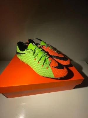 Nike Hypervenom Phelon III FG - Säljer ett par Nike Hypervenom Phelon III FG i färgen Electric Green/Black/Orange. Skorna är i nästan nyskick, endast använda ett fåtal gånger – inga skador, fräscha dobbar och mycket bra grepp kvar. Perfekta för spel på naturgräs (FG). Lätta, tight passform och bra bollkänsla – riktigt sköna match- och träningsskor. Men även skor som gör satt du blir som Neymar Jr när du spelar.