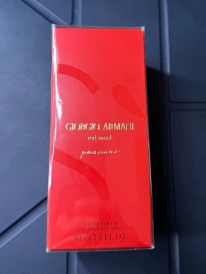 Giorgio Armani Red Mask Passion EdP - Giorgio Armani Red Mask Passion Eau de Parfum i en elegant röd förpackning med guldtext. Flaskan rymmer 50 ml och doften är intensiv och lyxig, perfekt för dig som vill sticka ut. Snygg design som känns exklusiv och modern.