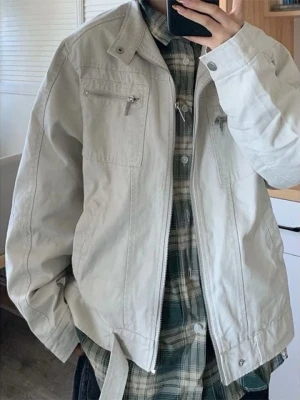 Beige jacka med dragkedja och ståkrage - Stilren beige jacka från Weekday med ståkrage och dragkedja framtill. Två bröstfickor med dragkedja och knappdetalj vid kragen. Jackan har en rak passform och är tillverkad i ett slätt tyg, perfekt för lager-på-lager-stil.