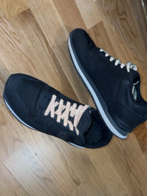 Moncler skor - Snygga svarta sneakers med vita och beige skosnören. Ovandelen är i textil och mockaimitation med meshpartier för extra andningsförmåga. Yttersulan är vit med grå inslag och ger en sportig look. Perfekta för dig som gillar stilrena och bekväma skor. (Pris kan diskuteras)