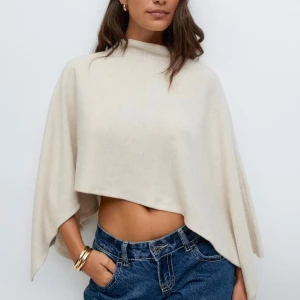 Beige stickad poncho med vida ärmar - Använt 1 gång super fint skick! Köparen står för frakten 