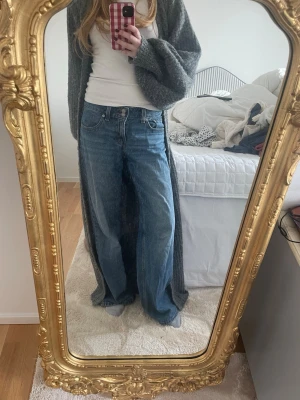 Blåa raka jeans med hög midja - Säljer ett par klassiska blå jeans med rak passform och låg midja. Nypris 849kr. Lite slitna nere på baksidan vid fötterna (se bilder)
