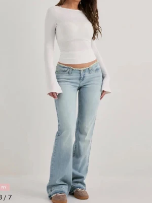 Ljusblå bootcut jeans - Säljer ett par ljusblå bootcut jeans med låg midja och klassisk femficksdesign. Jeansen har en avslappnad passform och är perfekta för en trendig vardagslook. Materialet är denim i bomull med lätt tvättad effekt för en cool vintagekänsla.