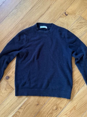 Svart stickad tröja från Samsøe Samsøe - En klassisk mörkblå stickad tröja från Samsøe Samsøe. Perfekt för lager-på-lager och enkel att matcha med olika outfits. Materialet känns mjukt och bekvämt.