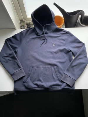 Ralph Lauren hoodie - Marinblå Ralph Lauren hoodie i storlek L. Hoodien är i okej skick, lite nopprig vid luvan men inga hål. Skriv om ni vill ha fler bilder eller prisförslag!