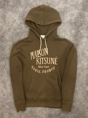 Maison Kitsuné Hoodie - Säljer denna riktigt feta hoodien från Maison Kitsuné i storlek M! Hoodien har en schysst olivgrön färg och ett riktigt stilrent tryck på framsidan. Nypris ligger runt 3000kr! Perfekt nu inför våren och passar bra om du vill ha en mer avslappnad stil. Priset är inte hugget i sten så kom gärna med förslag, tveka heller inte på att skriva om du har några frågor eller funderingar.