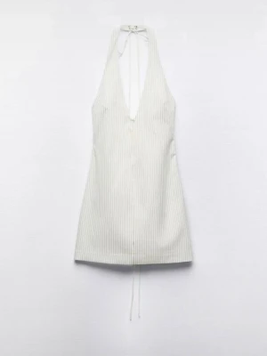 Vit randig halterneck miniklänning - Snygg vit kortklänning med tunna vertikala ränder och halterneck med knyt i nacken. Djup v-ringning framtill ger en trendig look. Perfekt för varma dagar och sommarens alla tillfällen.