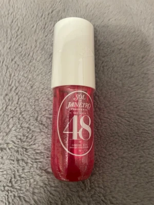 Sol de Janeiro Cheirosa 48 parfymmist - Sol de Janeiro Cheirosa 48 är en parfymmist i en snygg rosa flaska med vit kork. Doften är inspirerad av brasiliansk energi och flaskan har en rundad form som är enkel att ta med i väskan. Perfekt för dig som gillar fräscha och söta dofter.