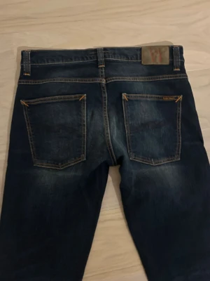 Nudie grim trim  - Säljer dessa sjukt feta Nudie jeans. Inprincip helt nya. Sjukt snygg tvätt. Modellen är Grim Trim. Storlek 34/36 men de är lite små i storleken så sitter mer som 34/34. Passar dig som är 188-2 m. Hör av dig vid minsta lilla fundering! 