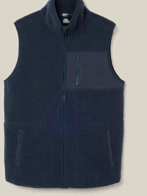 Mörkblå fleeceväst med dragkedja - Mysig mörkblå fleeceväst med hög krage och hel dragkedja framtill. Västen har en bröstficka med dragkedja och två sidofickor. Perfekt att slänga på sig över en tröja för extra värme. Enkel och stilren design.