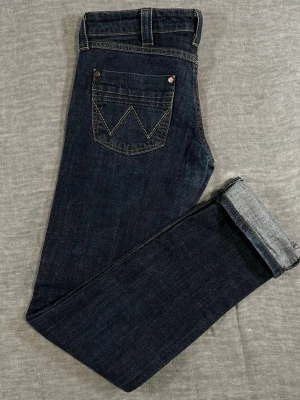 Wrangler Low Rise Dark Rinse Jeans W29 Y2K Slim Fit - Wrangler dark rinse low rise jeans with clean slim straight fit. Subtle fade starting to break in nicely. Slight stretch so they’re comfy but still structured. Giving early 2000s / indie western vibe. Perfect with boots or sneakers.  Measurements (flat): Waist 37.5 cm (≈W29–30) Rise 20 cm Thigh 23.5 cm Inseam 83 cm Leg opening 16 cm Back rise 44 cm  Used condition.
