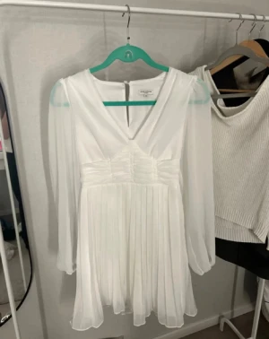 Vit klänning  - Säljer en jättefin vit klänning från Bubbleroom i storlek XS. Klänningen har långa ärmar, en smickrande V-ringning, markerad midja, osv. Perfekt på varm soliga sommardagar! Kan användas som exempelvis en skolavslutnings klänning men även som en studen klänning!! Har kommit till användning endast 2 gånger köpt för 420kr inne på bubblerooms hemsida! Djur och rökfritt hem, pris kan diskuteras! Detaljer: Vävd kvalitet * Drapering i midjan * Smock baktill *ballongerna med resår vid ärmsluten