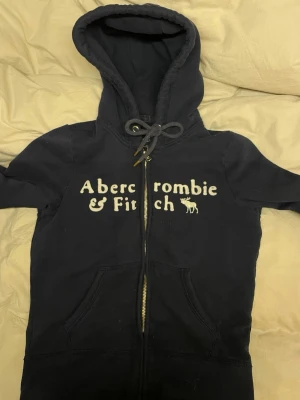 Marinblå hoodie från Abercrombie & Fitch - Mörkblå hoodie från Abercrombie & Fitch! Sitter riktigt fint men tyvärr för liten för mig💙 Pris kan diskuteras vid snabb affär