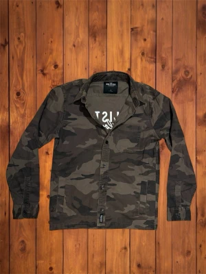 Vintage Hollister Printed Overshirt (sjukt sällsynt) - Säljer nu denna vintage sällsynta och asfeta overshirten från Hollister (California). Den är sjukt ovanlig och har en riktigt nice design på ryggen som visar hur unik den är. Det var inte många liknande producerade med denna typ av design vilket gör den extra nisch. Den är i otroligt bra skick och är ett galant plagg nu till våren. Storlek är S och passar som S möjligtvis en mindre M, se måtten nedan. Vid funderingar är det bara att skriva! B=68cm A=53cm