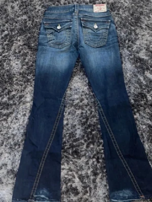 Blå True Religion jeans - Super snygga true religion jeans i bra skick💙 Midja: 37cm, innerbenslängd: 80cm. Pris kan diskuteras vid snabb affär!
