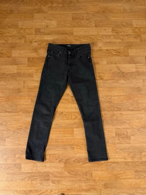 Svarta slim fit jeans från H&M - Snygga svarta slim fit jeans från H&M med klassisk femficksmodell och normalhög midja. Jeansen har raka ben och stängs med knapp och dragkedja. Perfekta till en avslappnad streetstyle-look.