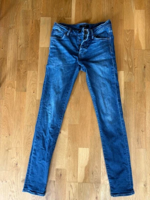 Blå slim fit jeans från Neuw - Snygga blå slim fit jeans från Neuw med klassisk femficksdesign och dragkedja. Jeansen har en modern passform och är tillverkade i denim med lätt stretch för extra komfort. Perfekta för dig som gillar en stilren look.