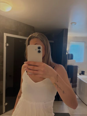 Vit sommarklänning - Säljer en söt vit klänning med smala axelband och v-ringad hals. Klänningen har volangdetaljer nedtill, perfekt för varma dagar. Enkel och stilren design som passar till många tillfällen.🤍