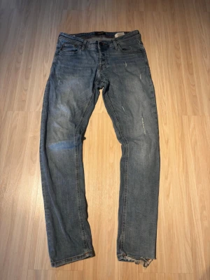 Blå slitna jeans från Jack&Jones - Tjena! Säljer dessa snygga blå jeans med slitnigar från Jack&Jones. !skada vid skrevet! Storlek W31 L32. Pris:199kr